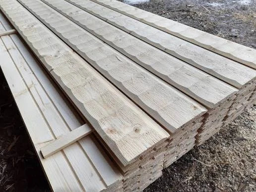 Stapel med obehandlade panelbrädor utomhus, profilerade ytor vända uppåt